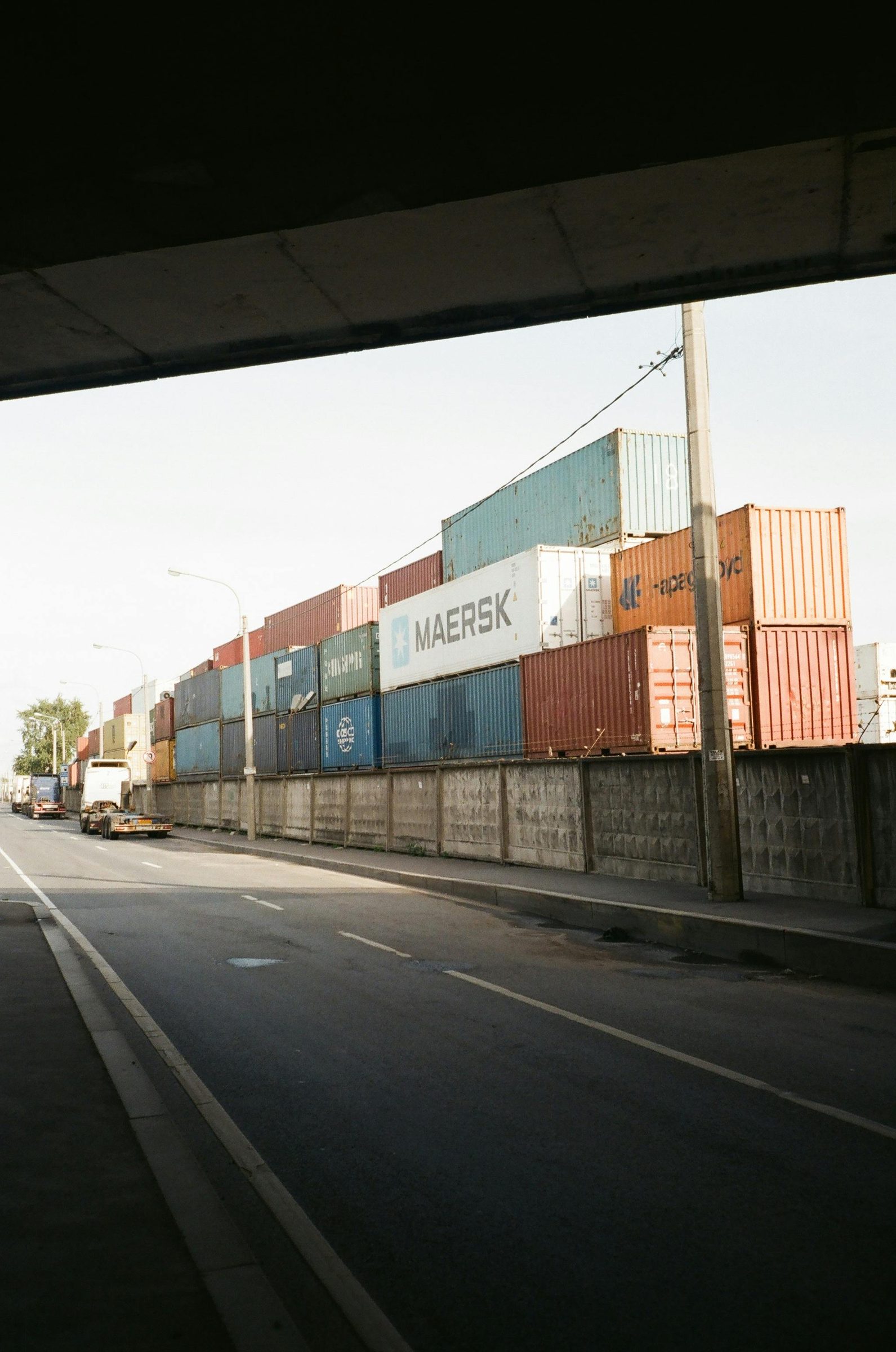 Stacked shipping containers seen from the road into the port